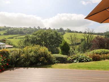 A garden view with green hills and trees at Dan Castell Cottage in Llandeilo, Carmarthenshire