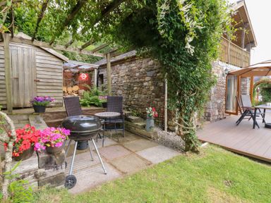 A garden with a barbecue and seating area at Dan Castell Cottage, Llandeilo, Carmarthenshire