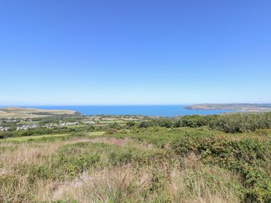 A coastal landscape with fields, houses, and the sea in the distance at Dolwylan in Newport Pembrokeshire