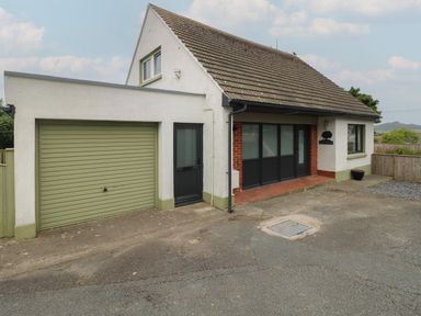 A house with a garage door and a driveway at Greenfields in St Davids Pembrokeshire