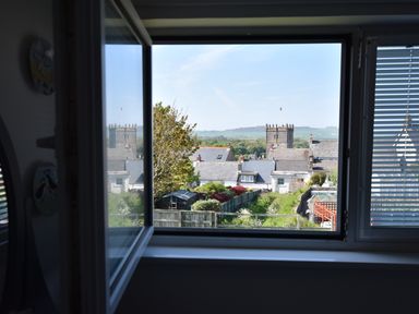 A view of houses gardens and a church tower through an open window at Greenfields in St Davids Pembrokeshire