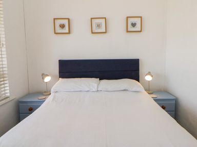 A bedroom with a bed and bedside lamps at Delyn Aur Tresaith, Ceredigion