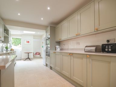 A kitchen with cabinets appliances a small round table and a doorway at Neverndale in Newport Pembrokeshire