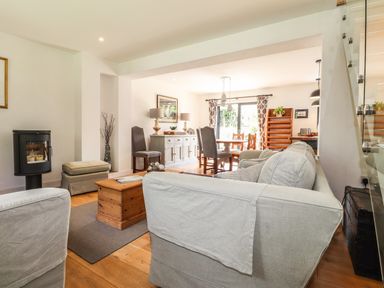 A living room with sofas a wooden coffee table dining table and chairs at Ty Cerrig in Newport Pembrokeshire