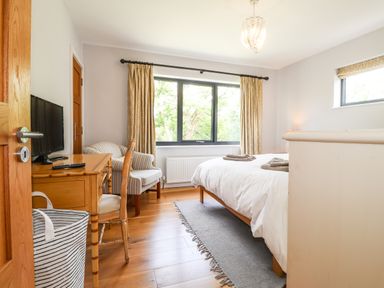 A bedroom with a bed towels on it a desk with a television and chairs at Ty Cerrig in Newport Pembrokeshire