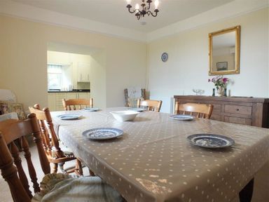 A dining room with a table covered in polka dot tablecloth and plates at Tremynydd Fawr in St Davids Pembrokeshire