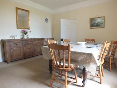 A dining room with a table covered by a polka dot tablecloth and wooden chairs around at Tremynydd Fawr in St Davids Pembrokeshire