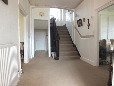 A hallway with carpeted stairs and doorways leading to other rooms at Tremynydd Fawr in St Davids Pembrokeshire