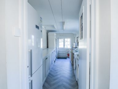 A laundry room with a refrigerator washer dishwasher and cabinets at Meadowlands in Dinas Cross Pembrokeshire