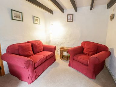 A living room with a sofa and an armchair at Panteg, Cardigan Llangoedmor Cardigan