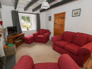 A living room with red sofas and a television at Panteg, Cardigan Llangoedmor Cardigan