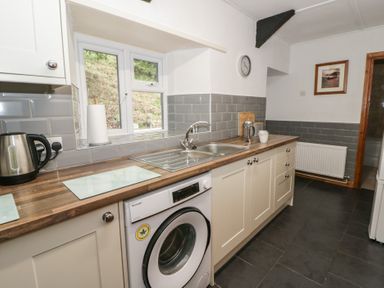 A kitchen with a sink, kettle, and washing machine at Panteg, Cardigan Llangoedmor Cardigan