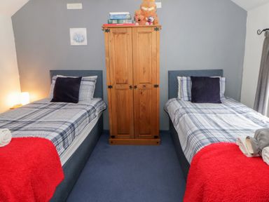 A bedroom with two single beds and a wardrobe at Panteg, Cardigan Llangoedmor Cardigan