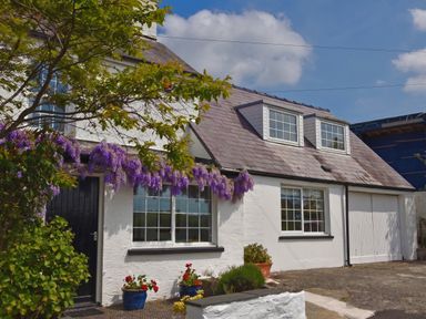 A house with purple flowers and windows at Beach Retreat in Aberporth