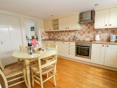 A kitchen with a table and chairs at Beach Retreat in Aberporth