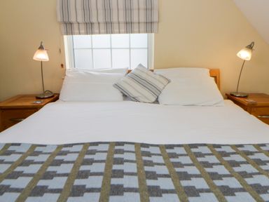 A bedroom with a bed and nightstands at Beach Retreat in Aberporth