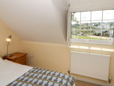 A bedroom with a bed and lamp at Beach Retreat in Aberporth