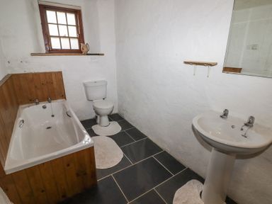 A bathroom with a bathtub toilet and sink at Panteurig Cottage Strumble Head Goodwick Pembrokeshire