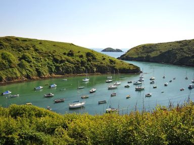 A bay with many anchored boats and green hills surrounding the water at Panteurig Farmhouse in Strumble Head Goodwick Pembrokeshire