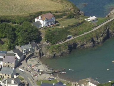 A coastal village with houses near a small bay and boats on the water at Beach Cottage in Little Haven Pembrokeshire