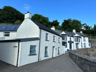 A cottage with a sign at the Swan Inn in Little Haven, Pembrokeshire