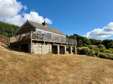 A house with a deck and steps in the outdoor area at Beach Cove Freshwater East, Pembrokeshire