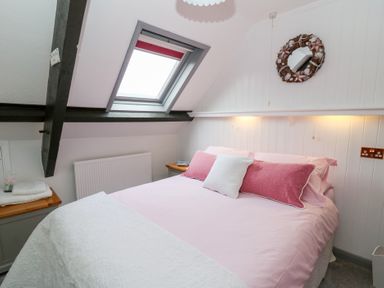 A bedroom with a bed and pillows under a skylight window at 5 The Coach House Broad haven Pembrokeshire