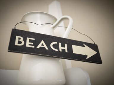 A white pitcher with a black sign hanging that says beach with an arrow at The Rock House in Fishguard Pembrokeshire