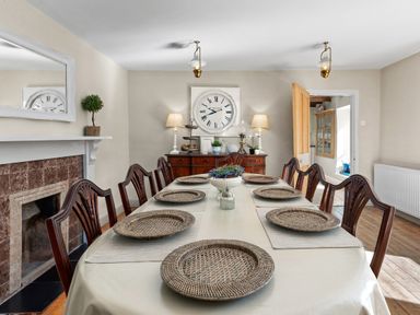 A dining room with a long table set with placemats and woven plates at The Rock House in Fishguard Pembrokeshire