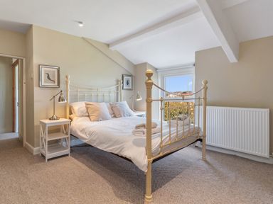 A bedroom with a metal framed bed with white linens and towels on the bed at The Rock House in Fishguard Pembrokeshire