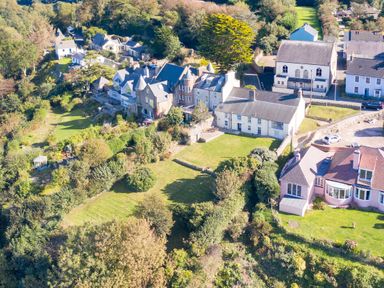 An aerial view of a village with houses gardens and trees at The Rock House in Fishguard Pembrokeshire