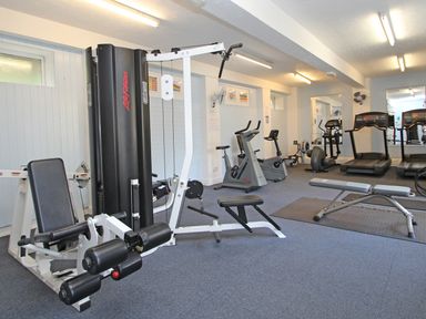 A gym room with exercise bikes treadmills weight machine and benches at 9 Manorcombe Bungalows St Ann's Chapel near Callington