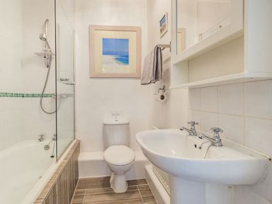 A bathroom with a bathtub shower toilet and sink at Peth Head Cottage in Wooler