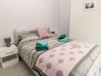 A bedroom with a bed linens and folded towels displayed on the bed at Scarborough Cottage in Driffield