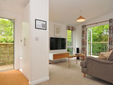 A living room with a television and sofa at The Hideout in Lanreath