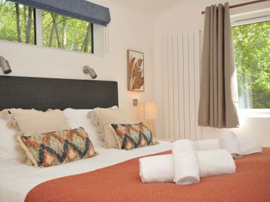A bedroom with a bed and pillows at The Hideout in Lanreath
