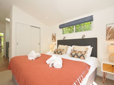 A bedroom with a bed and towels at The Hideout in Lanreath