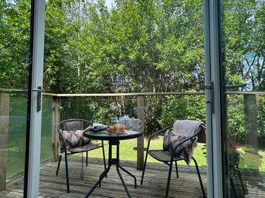 An outdoor seating area with a table and chairs at The Hideout in Lanreath