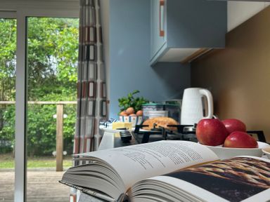 A kitchen with apples and a cookbook at The Hideout in Lanreath
