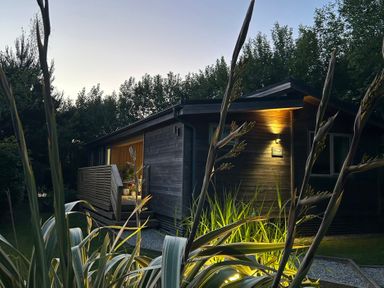 An exterior view of a cabin surrounded by plants at The Hideout in Lanreath