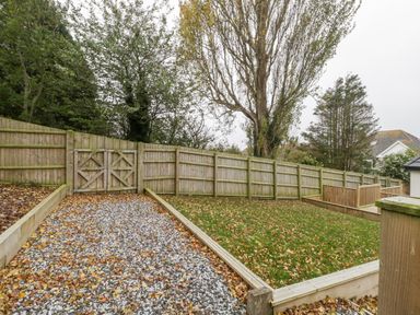 A fenced outdoor area with a gravel pathway and a grass lawn at Flat 2 38 Preston Road Weymouth
