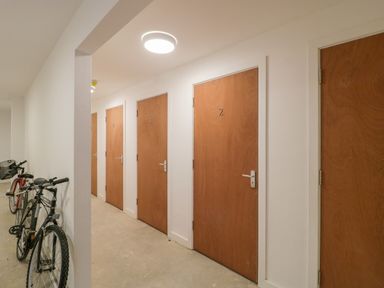 A hallway with numbered wooden doors and bicycles leaning against the wall at Flat 2 38 Preston Road Weymouth