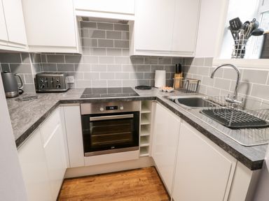 A kitchen with an oven sink kettle toaster and utensils at Parva Great Broughton near Stokesley