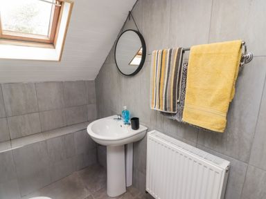 A bathroom with a pedestal sink mirror window and towels at Barn Court Cottage Narberth Pembrokeshire