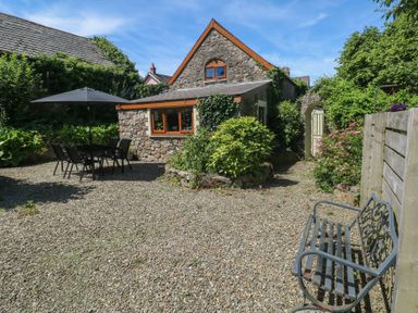 A garden with a table and chairs at Barn Court Cottage in Narberth, Pembrokeshire