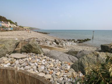A beach with pebbles and stones beside the sea at Barn Court Cottage in Narberth, Pembrokeshire