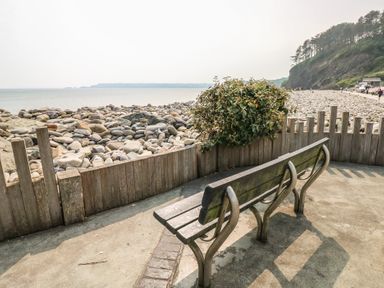 A bench overlooking rocks and the ocean at Barn Court Cottage Narberth, Pembrokeshire