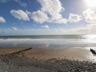 A beach with sand and wooden structures at Barn Court Cottage, Narberth, Pembrokeshire
