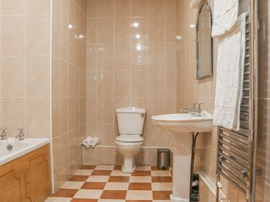A bathroom with a toilet sink bathtub and towel rail at Stoney Cottage in Narberth Pembrokeshire