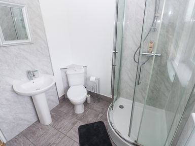 A bathroom with a sink a toilet a shower enclosure and a mirror at Smugglers in Lydstep